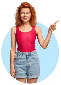 Smiling young woman with ginger hair wearing a pink top and denim shorts pointing a finger to the right on a transparent background